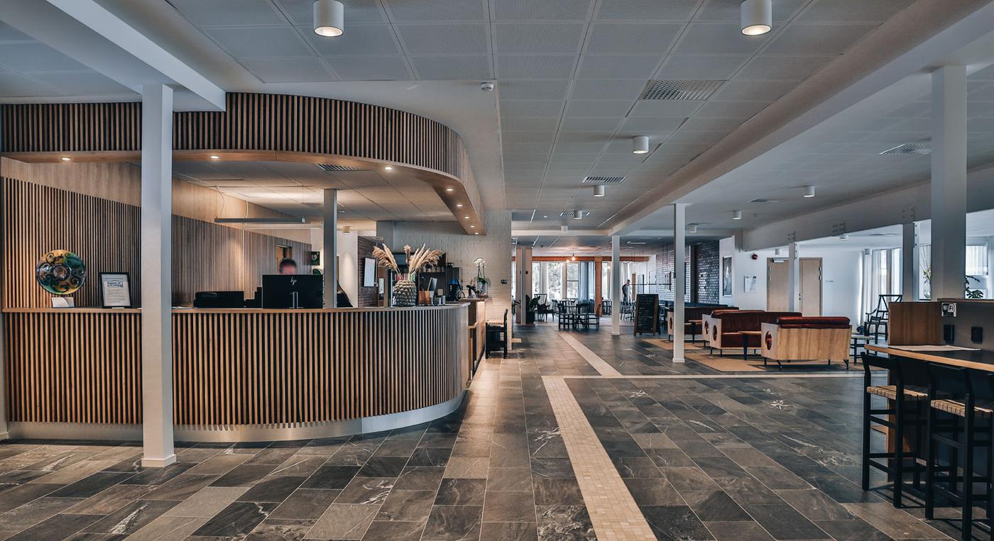 Receptionen på Ädelfors folkhögskola är i modern stil. Entrén innehåller också flera sittgrupper.