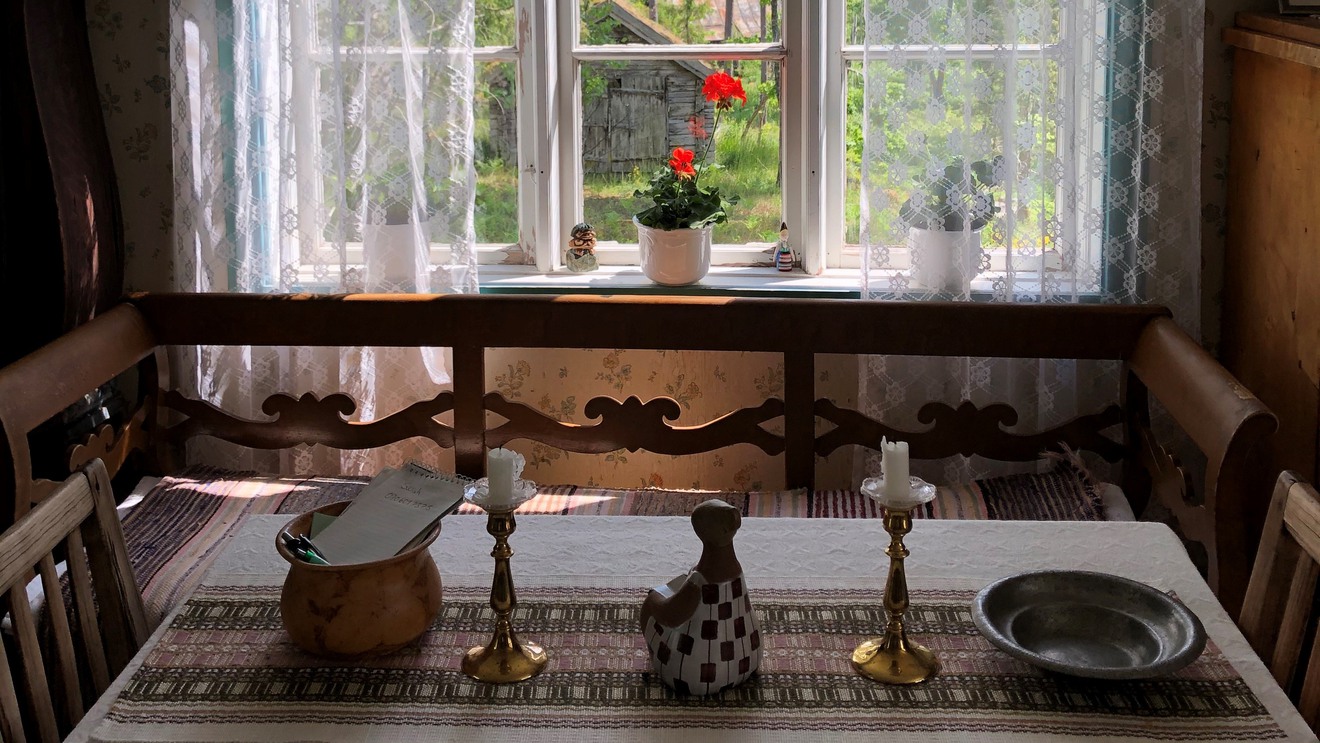 En kökssoffa och ett bord inne i Pälle Nävers diktarstuga