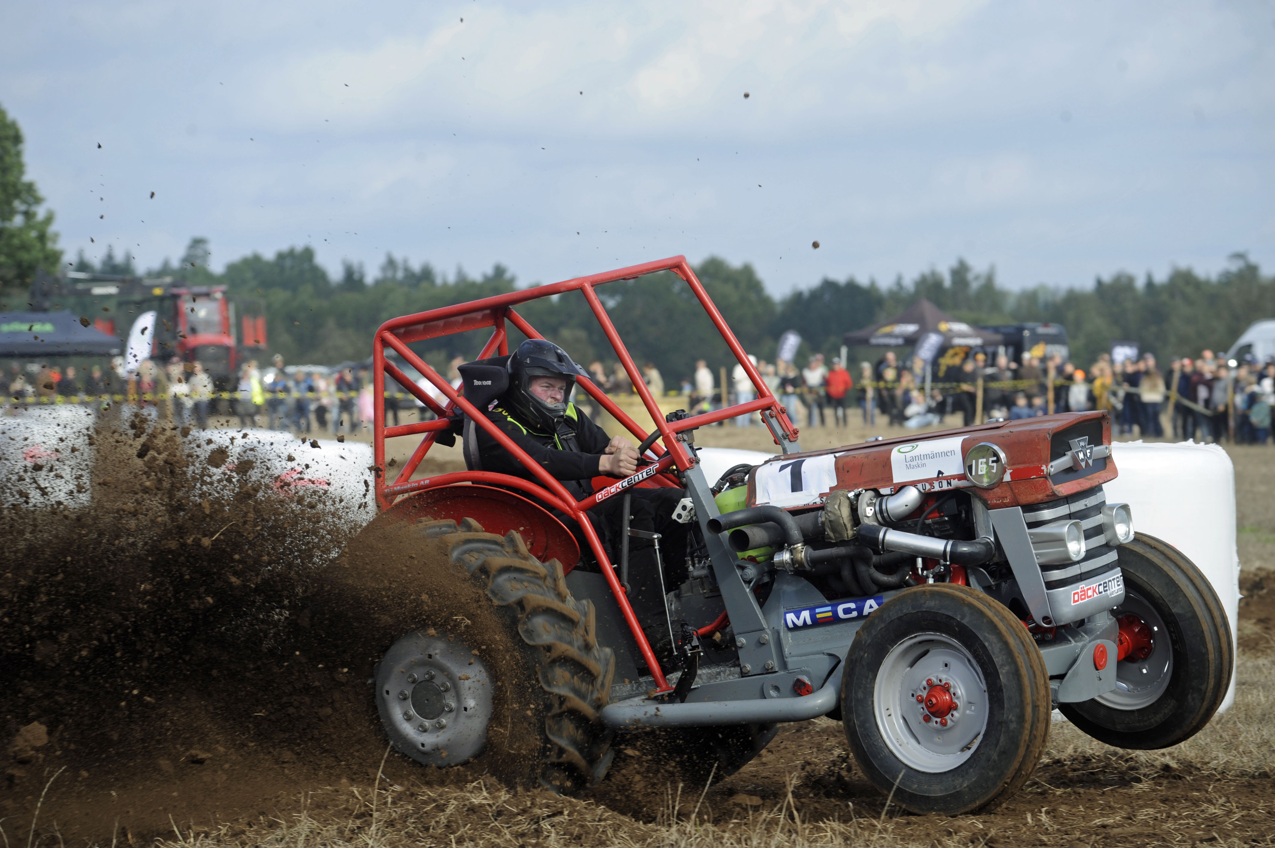 En förare kör med sin Massey ferguson så jorden sprutar