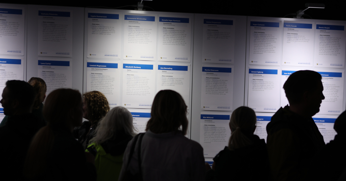 Vägg med affischer och siluetter av människor.