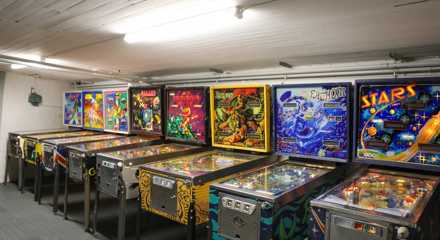 En rad flipperspel i ett rum.