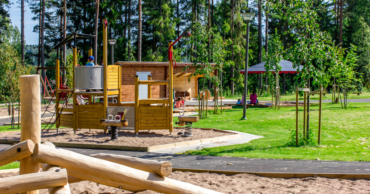En park med en lekplats och träd.