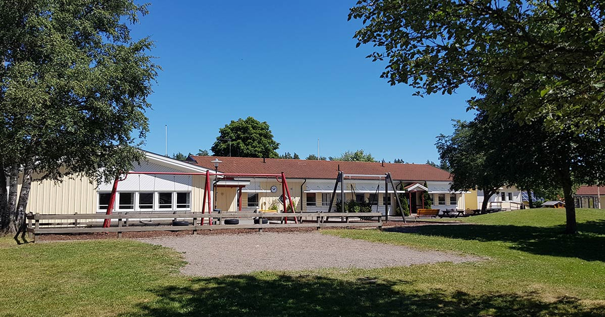 En byggnad med en lekplats framför sig.