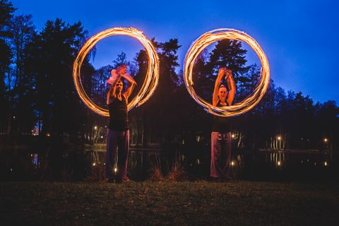 Bilden beskriver två personer som jonglerar med eld