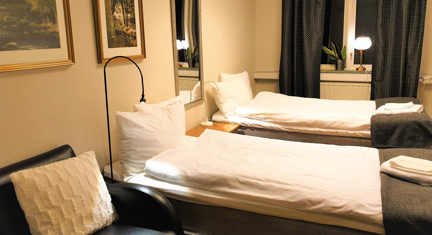 Två bäddade sängar i ett hotellrum