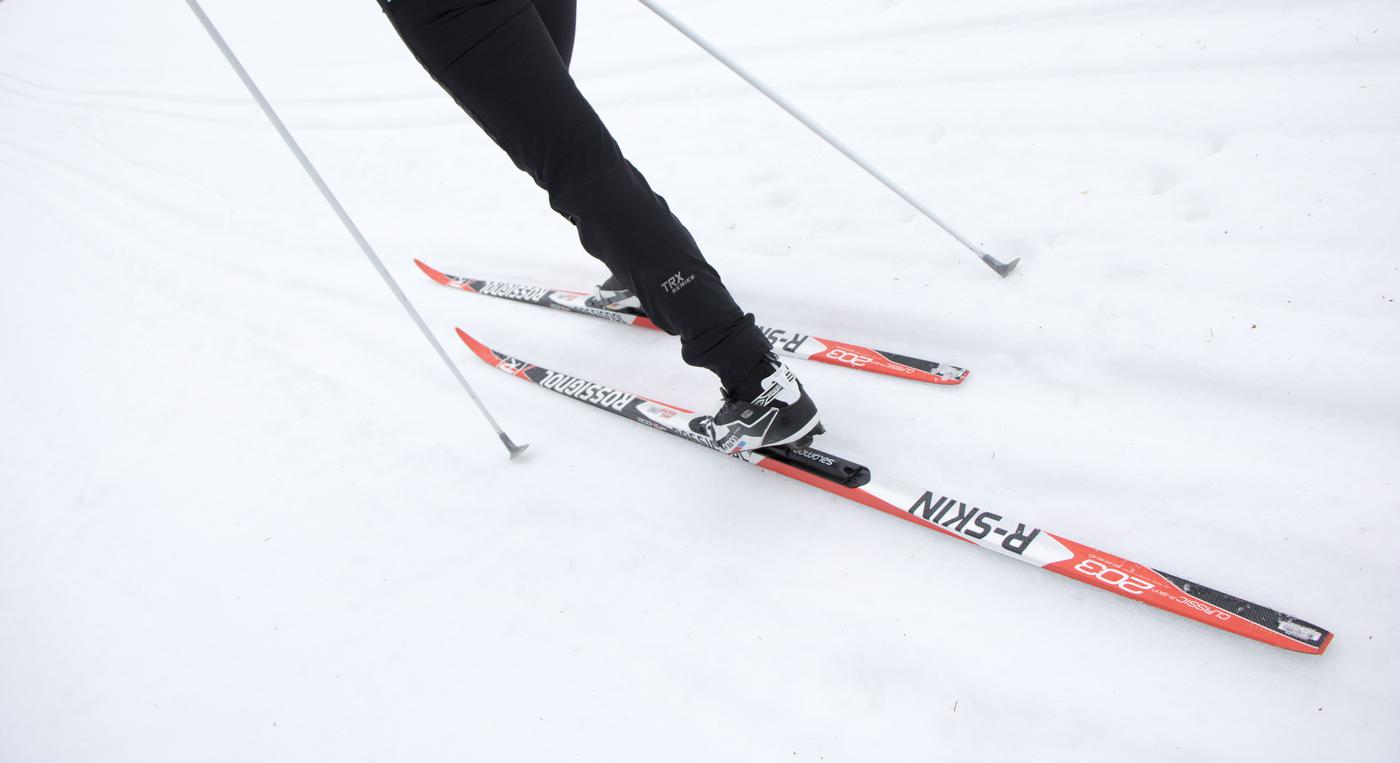 En skidåkare står på ett par längdskidor