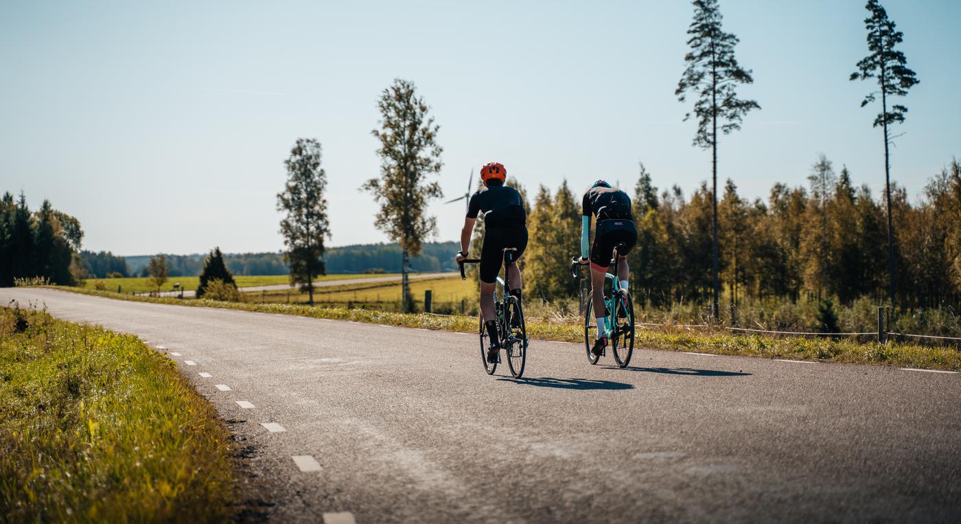 Två personer cyklar på en landsväg