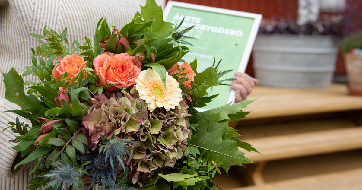 En blombukett med ett diplom i bakgrunden.