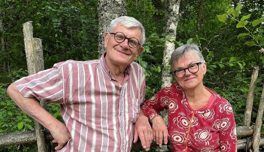 En man och en kvinna hänger mot en gärdsgård och ler avslappnat mot kameran.