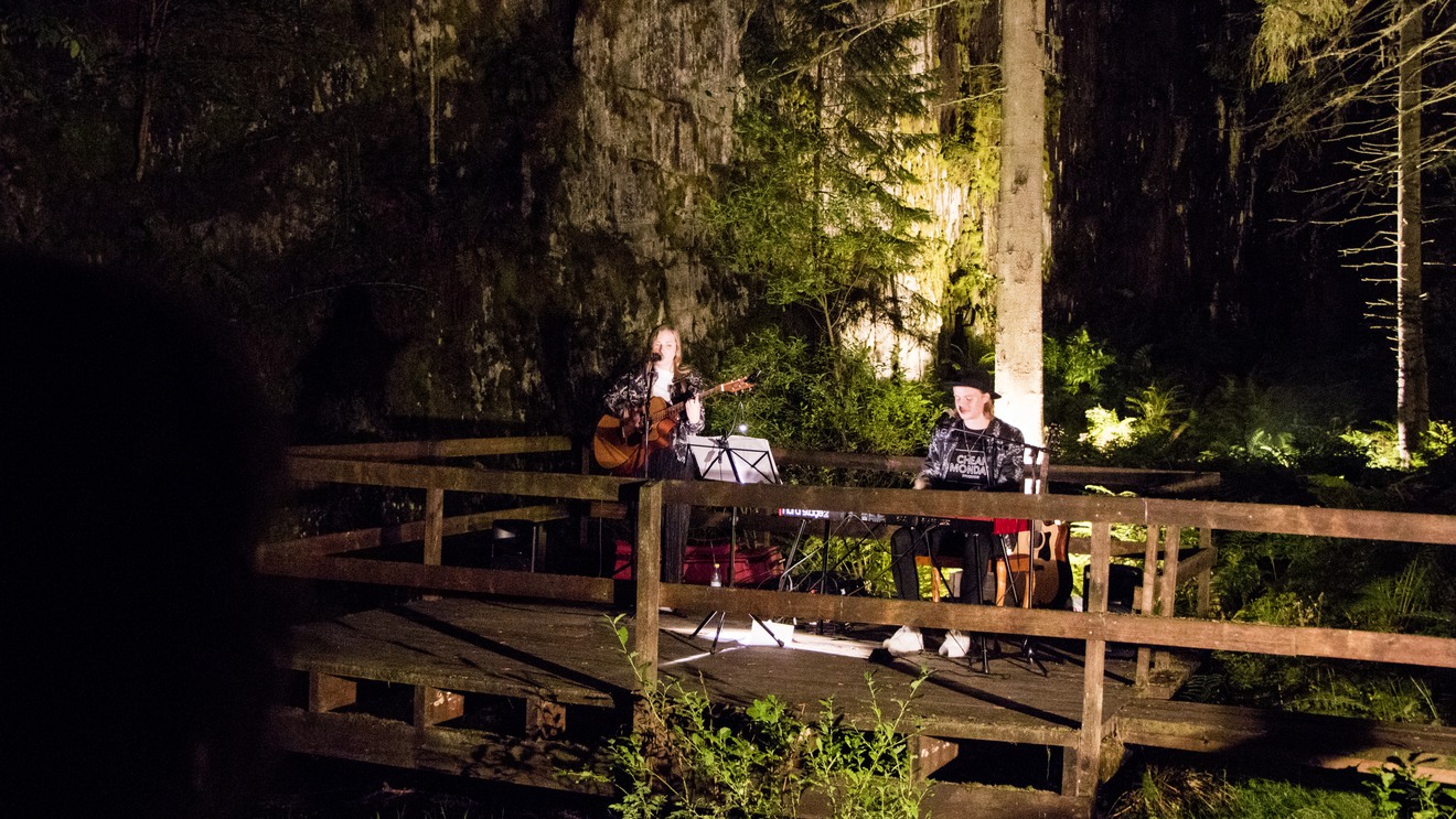 Två musiker står på ett trädäck mitt i dagbrottet Hörnebo skiffergruva.