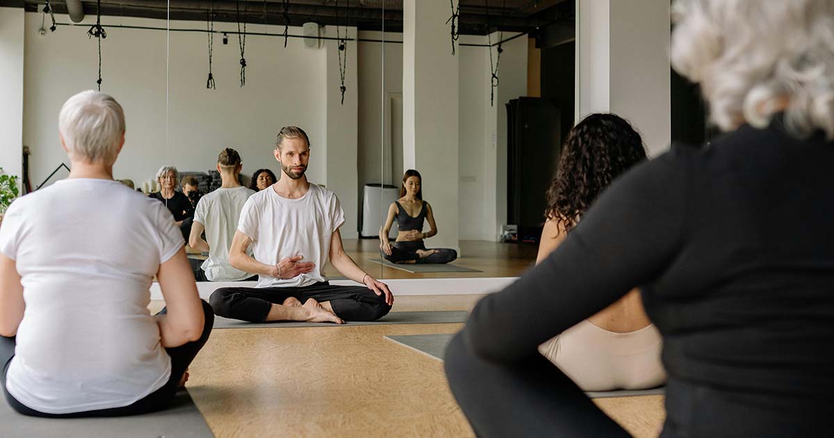 En grupp människor utför yoga i en träningssal.