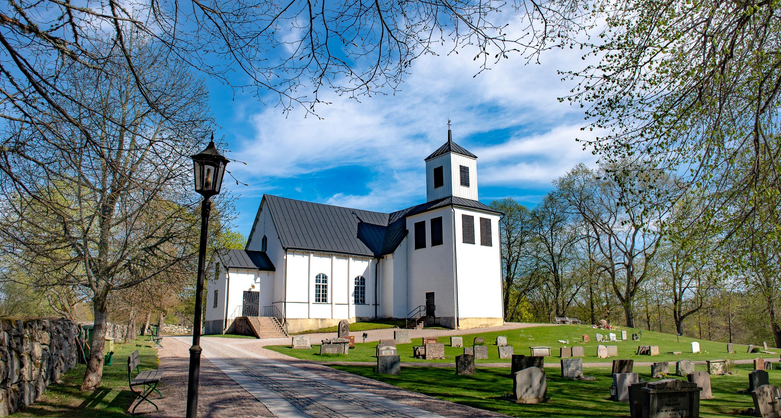 Näsby kyrka i sommargrönska.