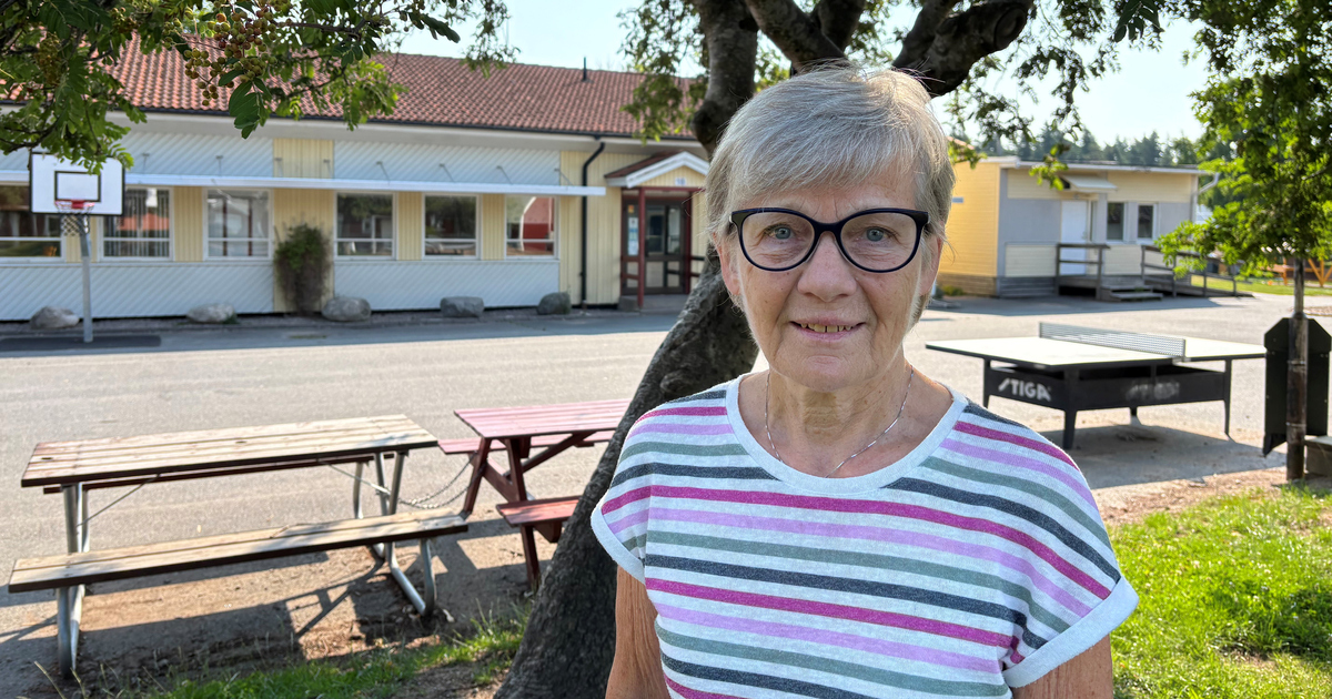 Äldre kvinna står på en tom skolgård.
