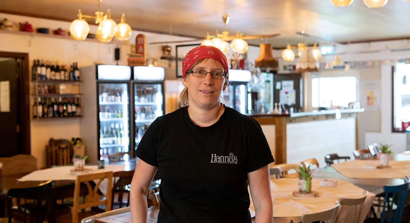 En kvinna med en bandana som står i en restaurang.