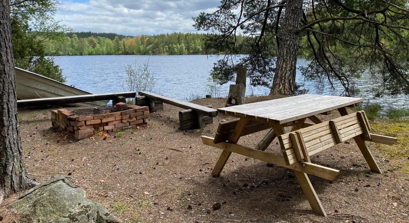 Ett picknickbord som står vid en sjö.
