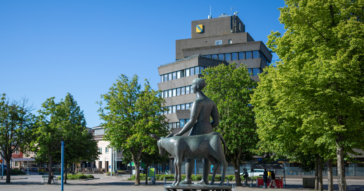 Skulptur vid fontänen i förgrunden och stadshuset i bakgrunden