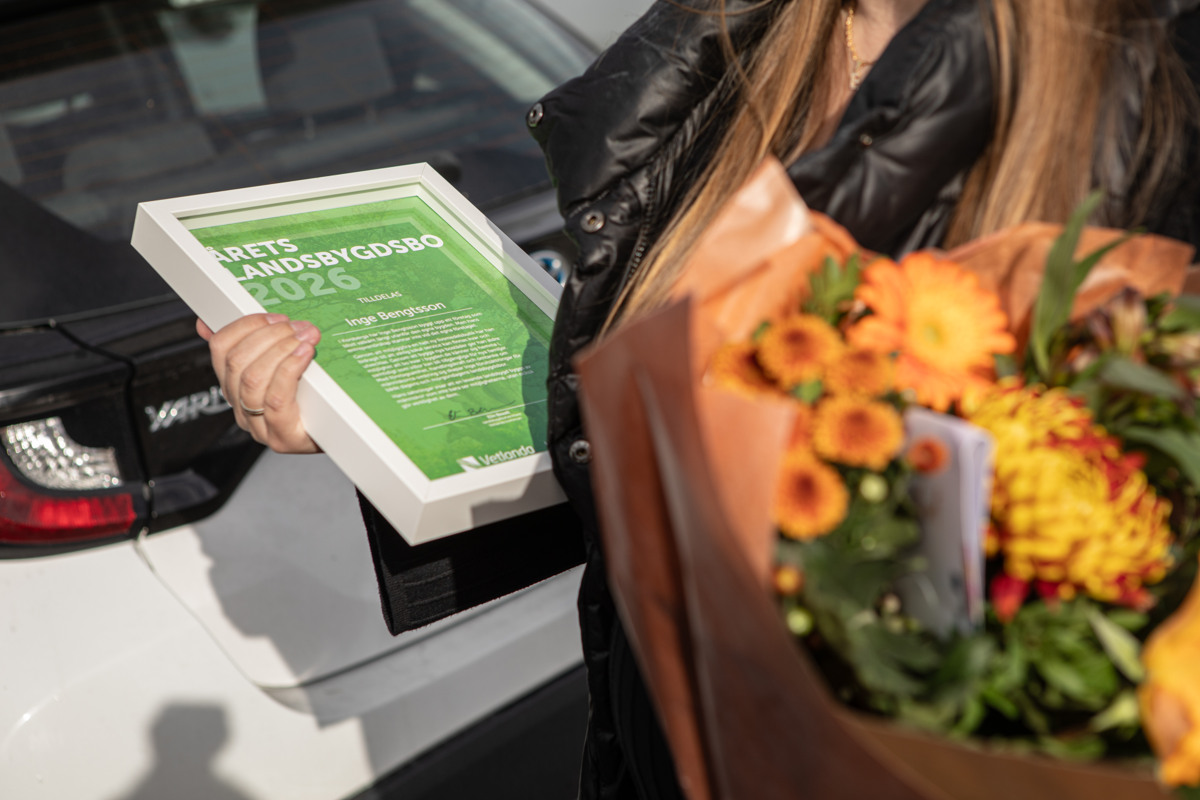 En kvinna som håller en bukett blommor framför en bil.