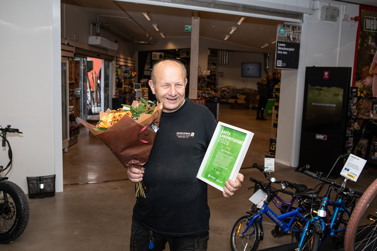 En man som håller en bukett blommor och en skylt.