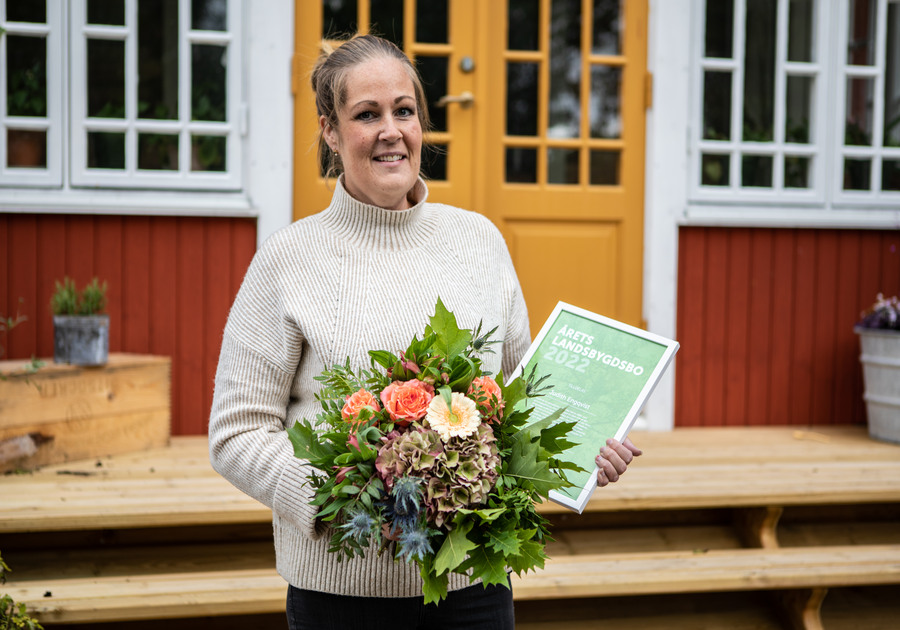 Judith Engqvist håller i en bukett blommor och ett diplom.