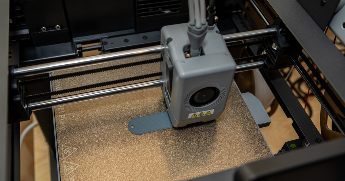 En 3d-printer arbetar fram en oval nyckelbricka.