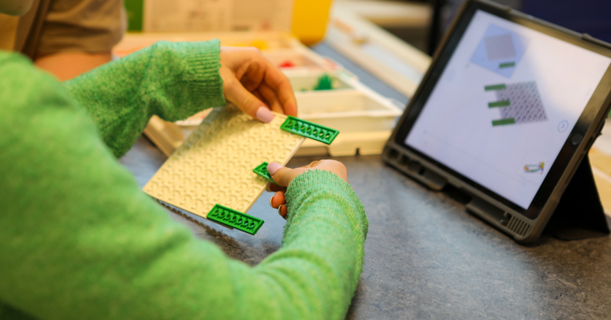 Ett barn leker med ett legoset.