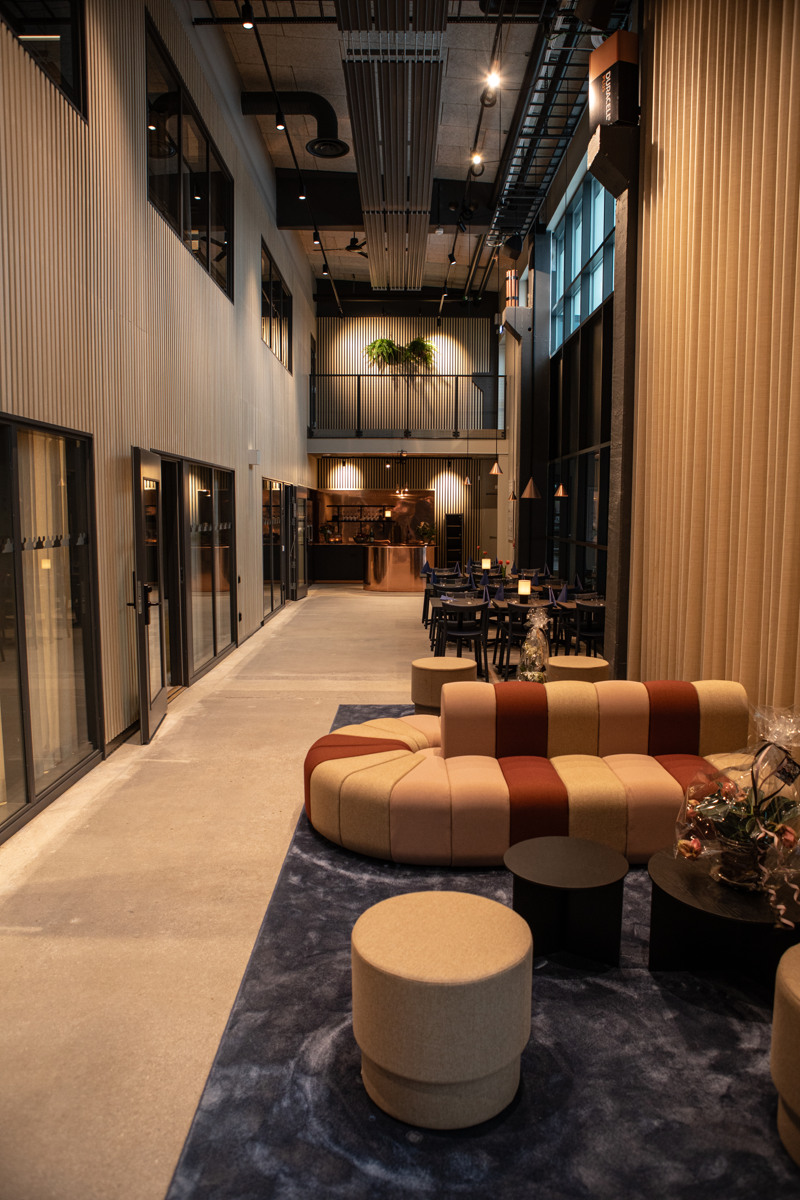 En modern lobby med soffa och pallar.