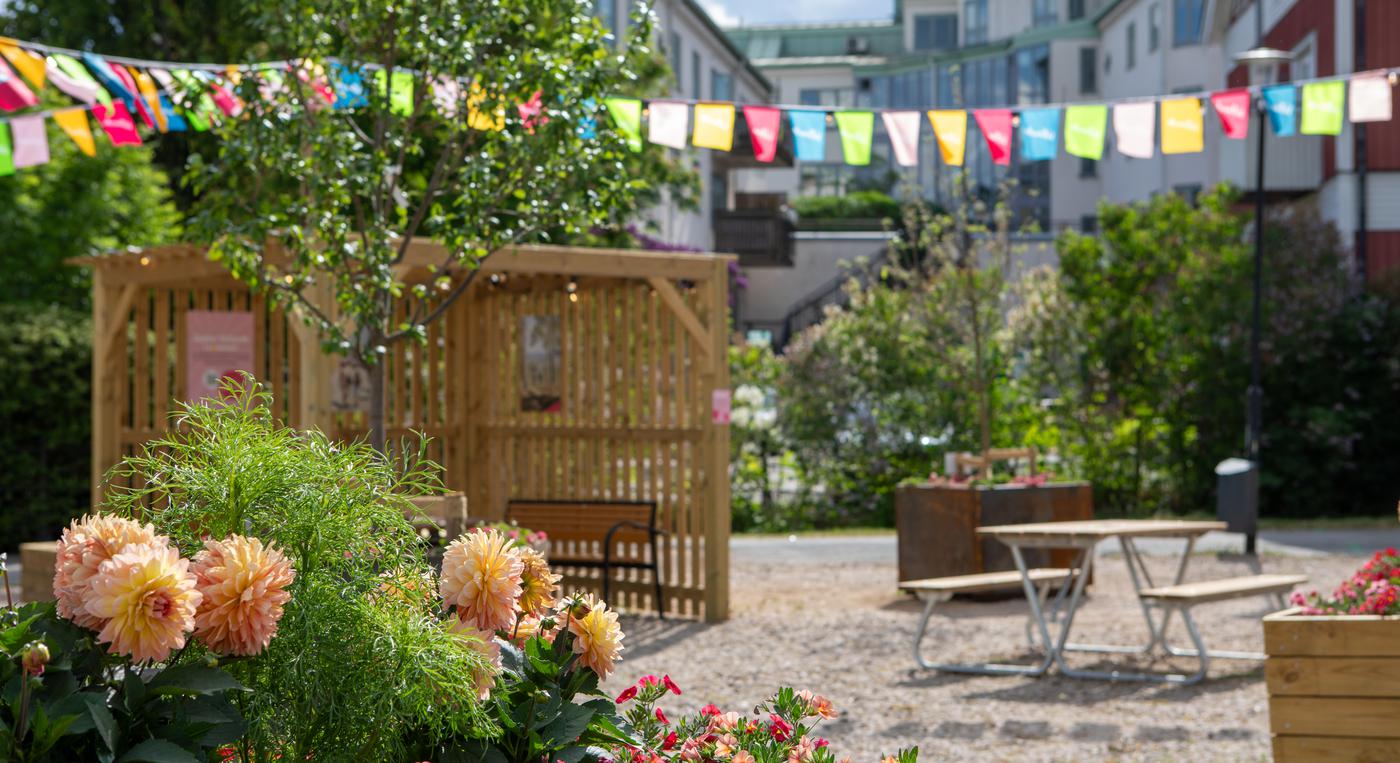 Vimplar, blommor och en pergola i centrala Vetlanda.