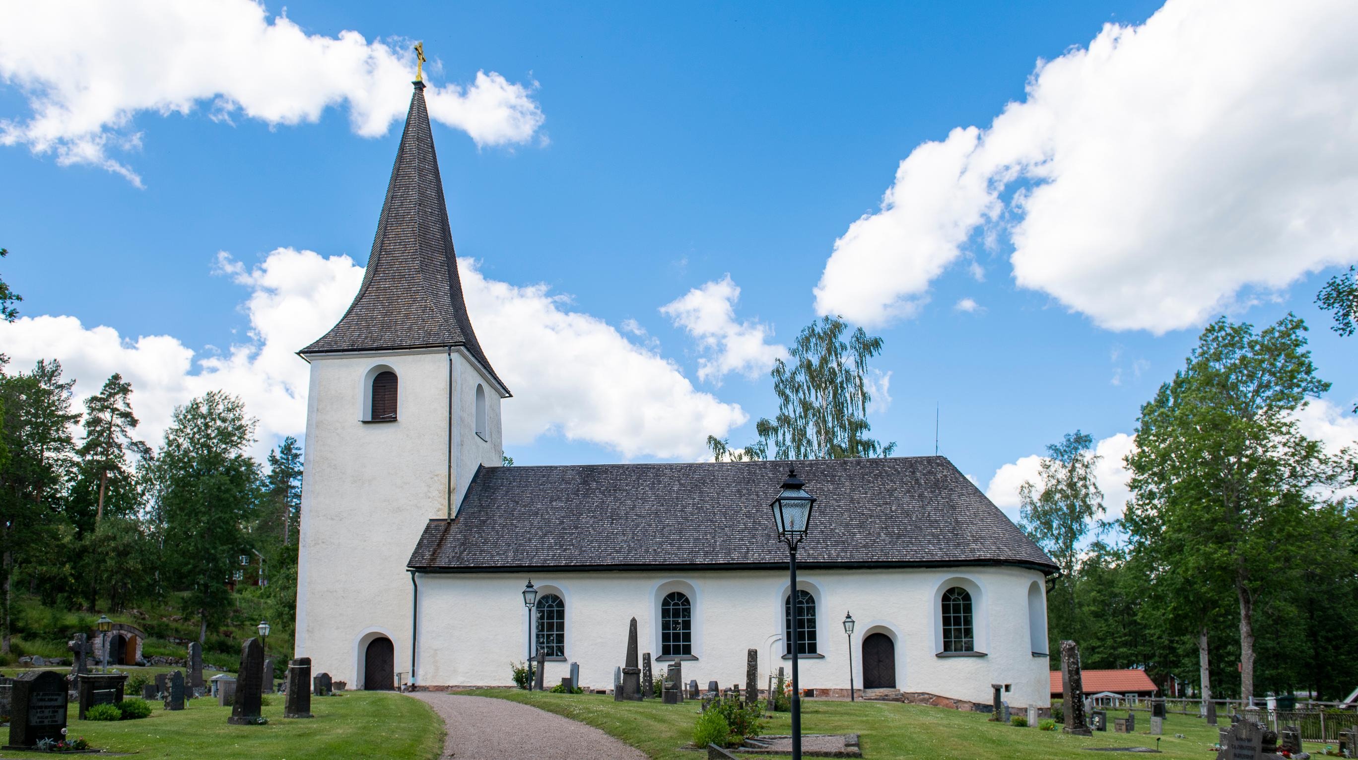 Karin tittar fram till höger i bild. Hon står uppe på en orgelläktare, så bakom henne skymtar altaret framme i en kyrka.