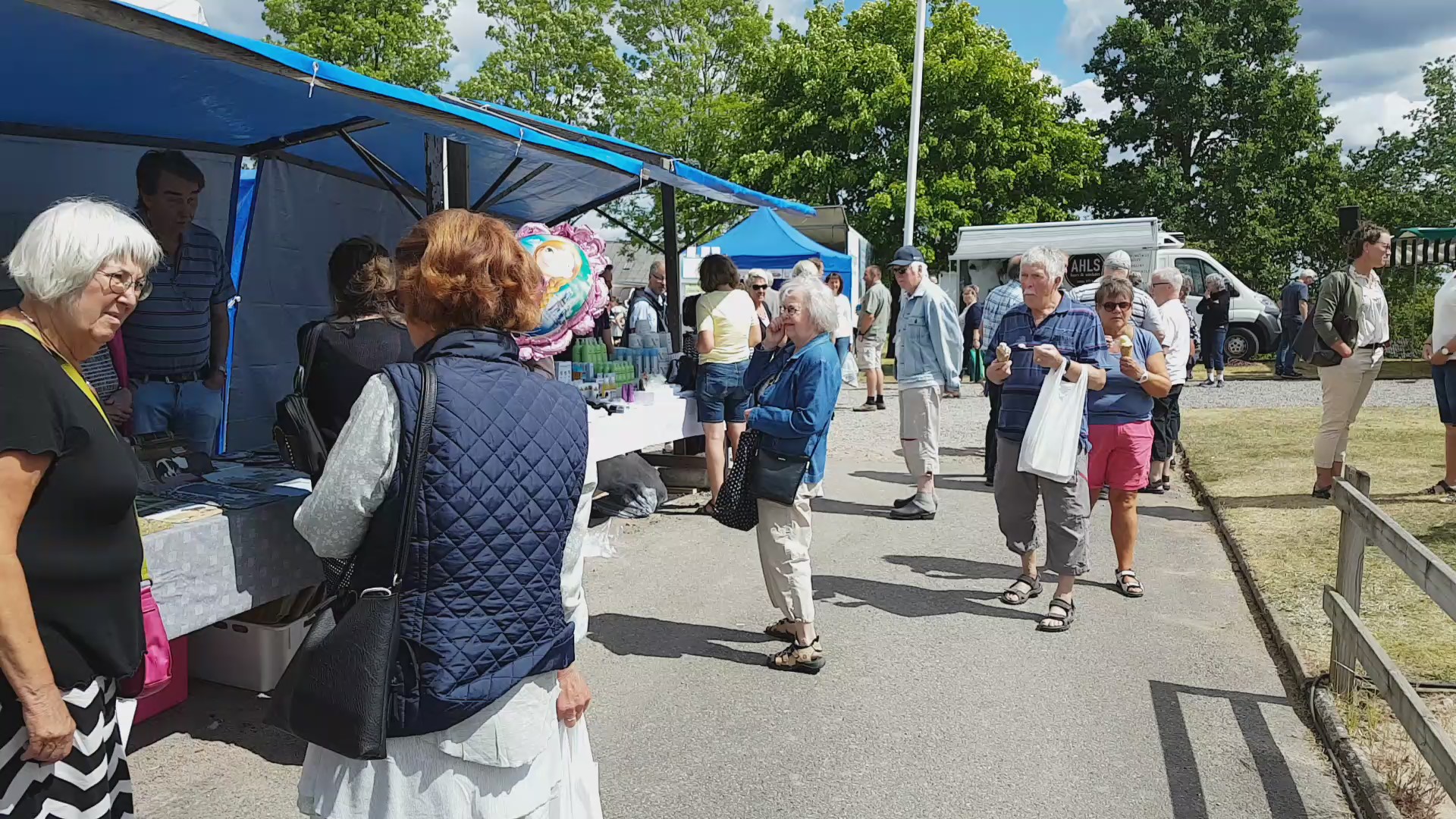 Marknadstånd med folk i rörelse