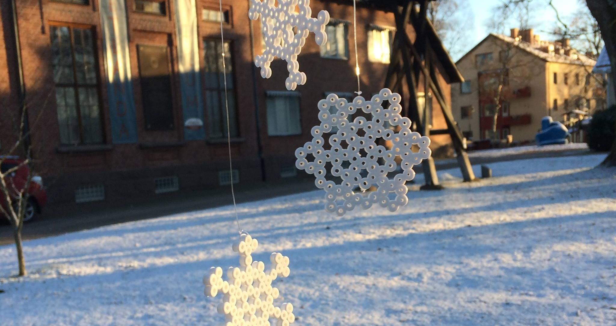 Snöflingor gjorda av pärlor. Museibyggnaden i bakgrunden.