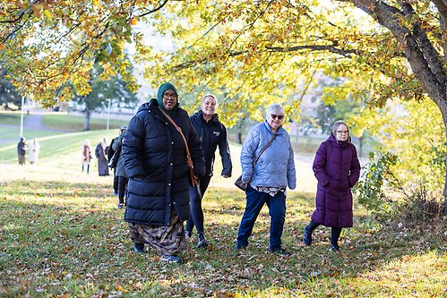 En grupp människor promenerar genom en park.