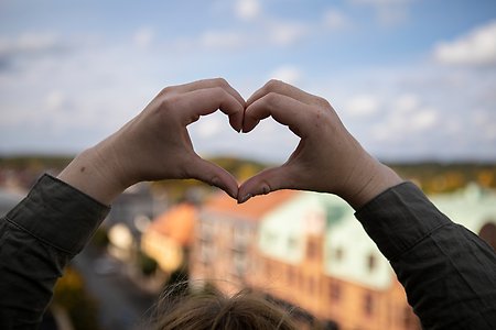 Två händer skapar ett hjärta.